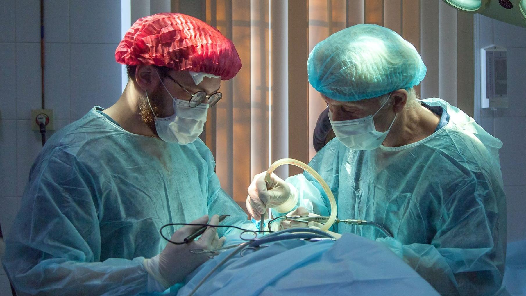 two men wearing blue lab coats